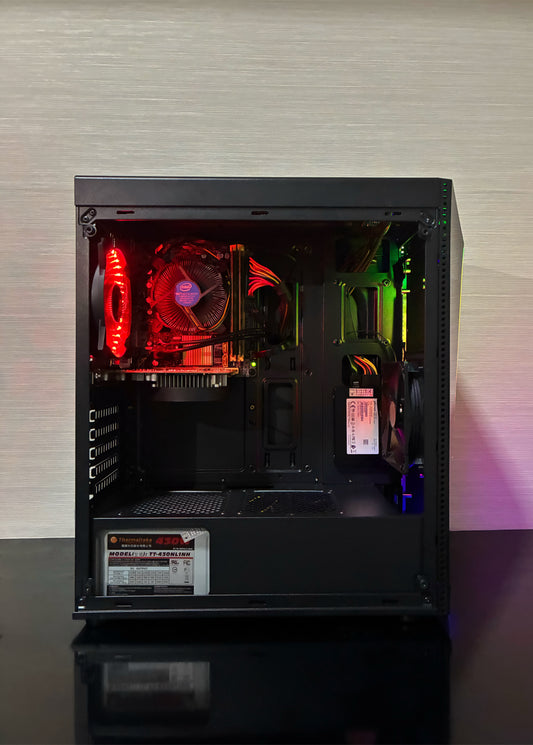 Vedere detaliată a interiorului unui PC Gaming BUENO START V2. Se disting placa de bază Asus H81, procesorul Intel Xeon E3-1220 v3 cu sistemul său de răcire, și placa video NVIDIA GTX 1050 de 2GB. Cablurile sunt organizate, iar iluminarea LED a ventilatorului spate Genesis și ventilatorul Antec RGB din față luminează componentele.