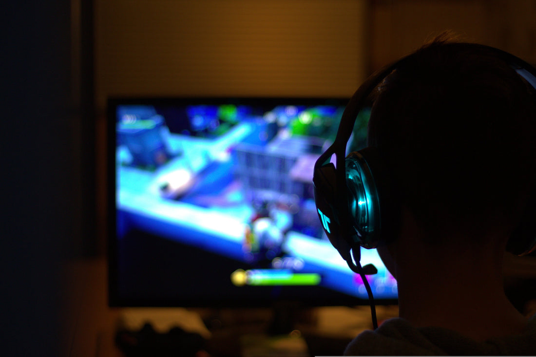 un baiat cu casti care joaca fortnite
