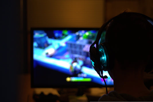 un baiat cu casti care joaca fortnite