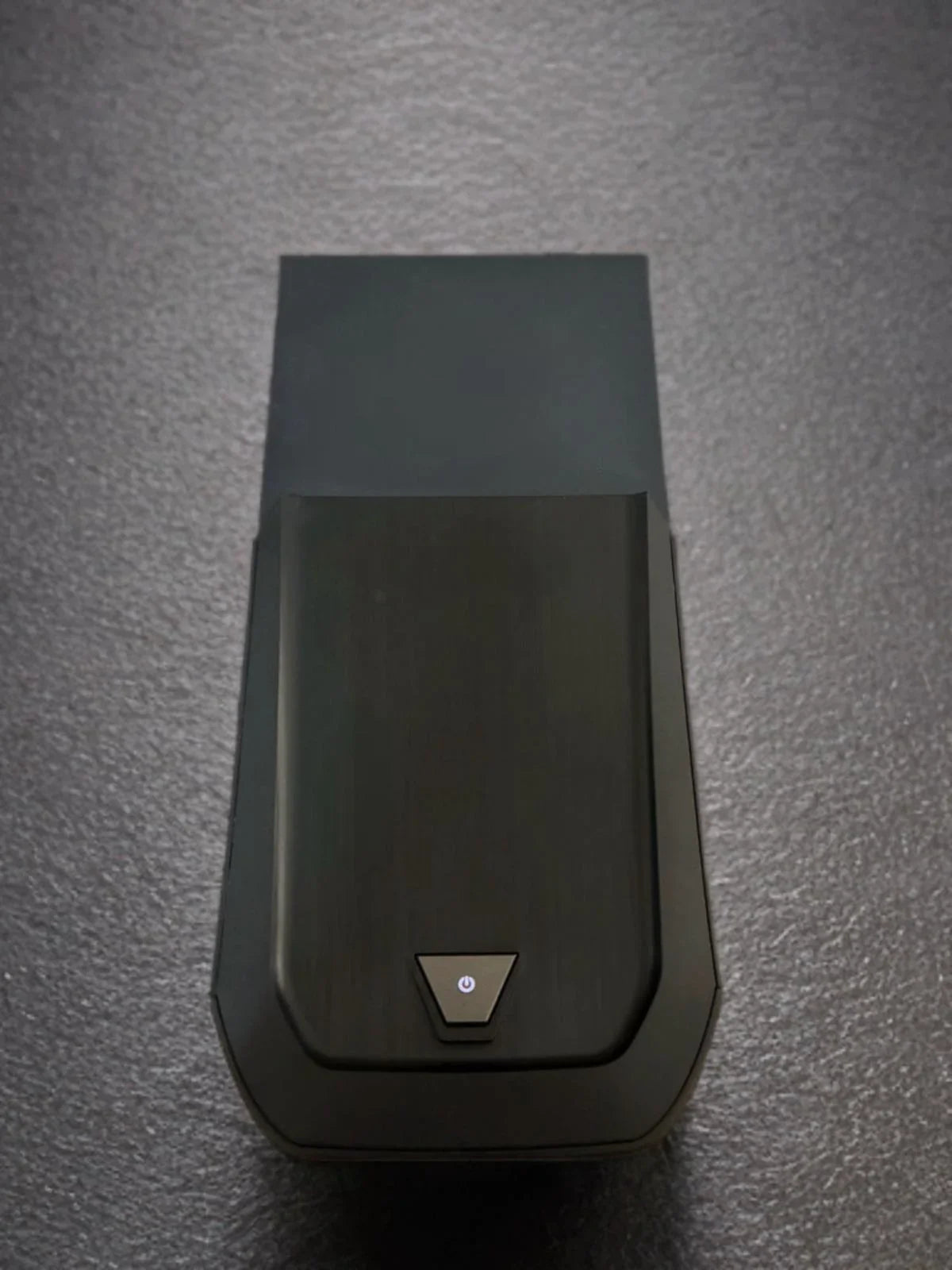 Refurbished black gaming PC tower with power button on textured surface